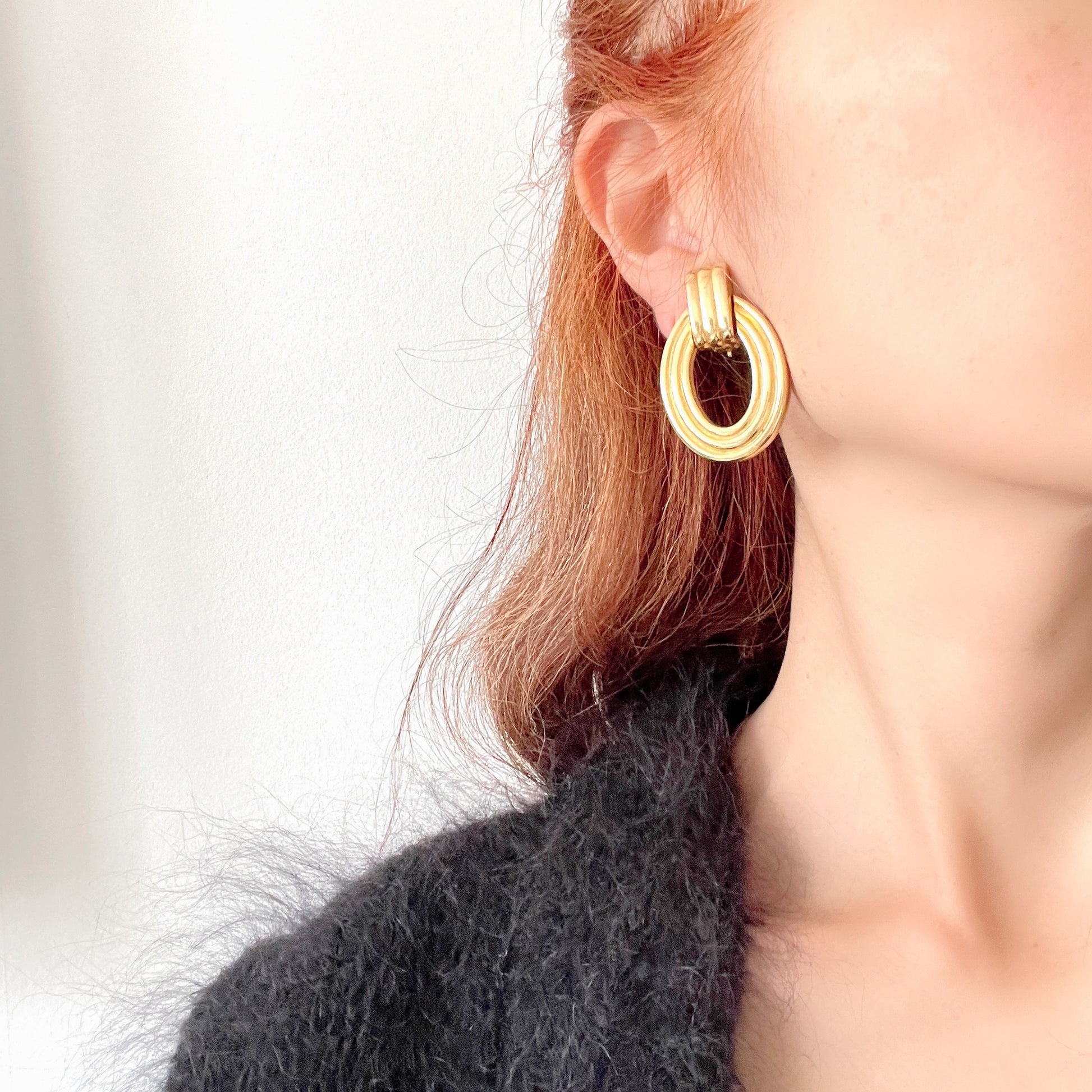 Gold-tone door knocker earrings with subtle linear detailing. ラインが入ったゴールドトーンのドアノッカーイヤリング。 
