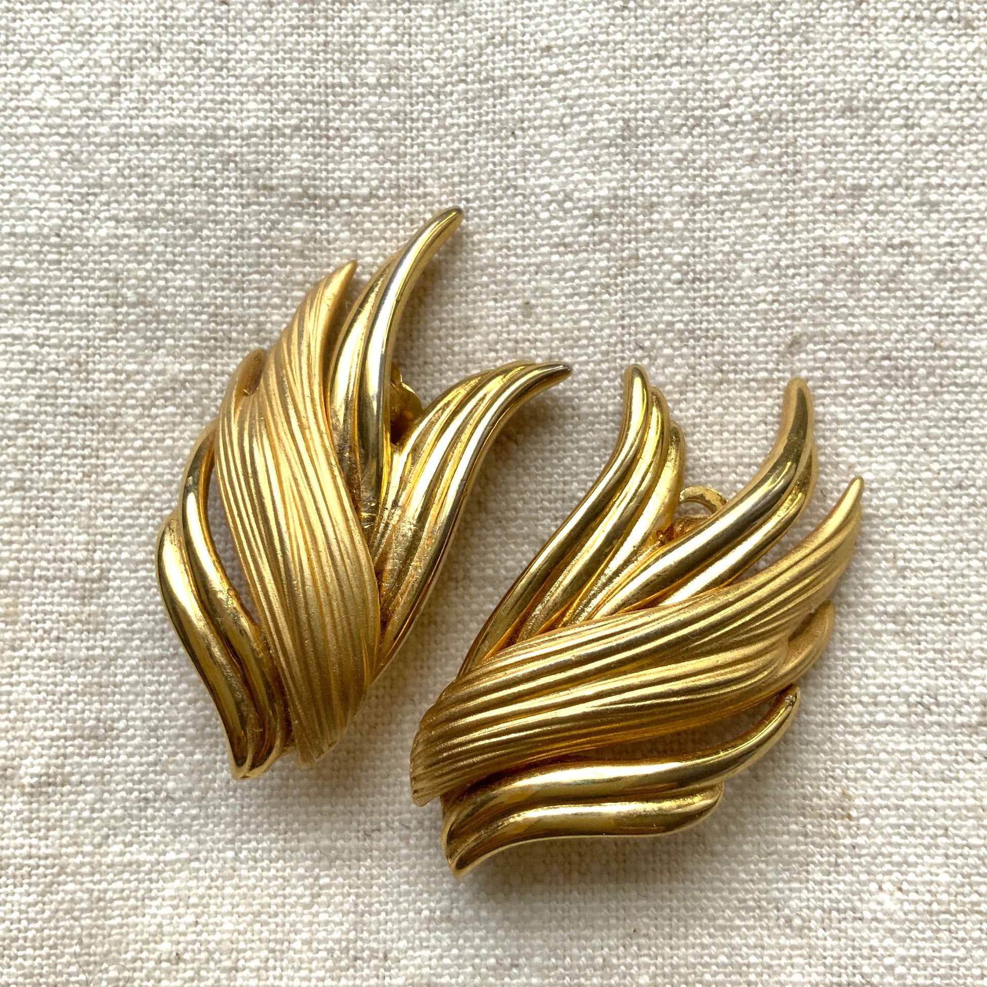 Gold-tone clip-on earrings with beautifully flowing lines. T 流れるようなラインが美しい、ゴールドトーンのクリップイヤリング。