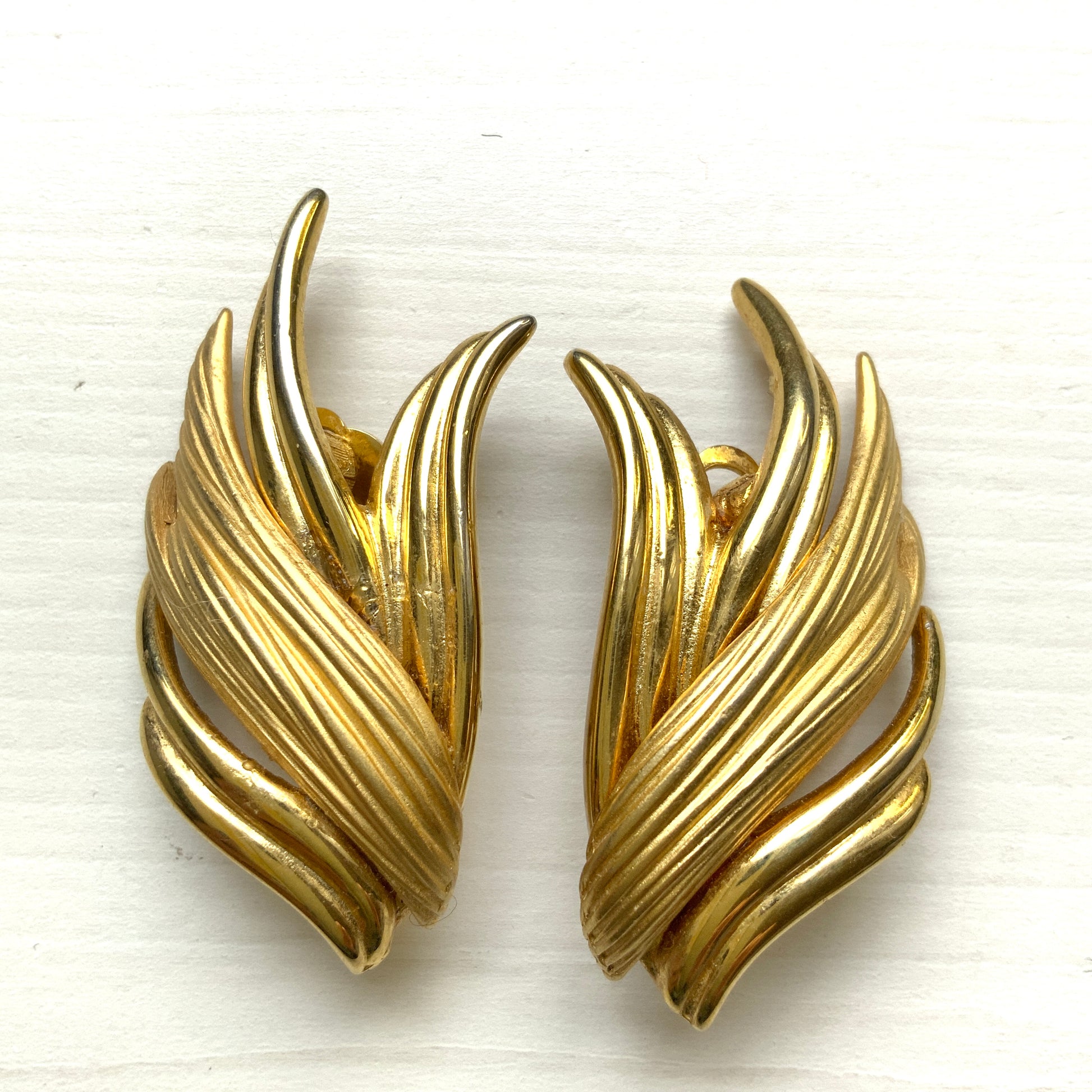 Gold-tone clip-on earrings with beautifully flowing lines. T 流れるようなラインが美しい、ゴールドトーンのクリップイヤリング。