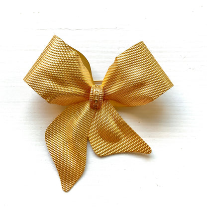Vintage brooch in the shape of a large gold-tone bow. 大きなゴールドトーンメタルのリボンのブローチ。