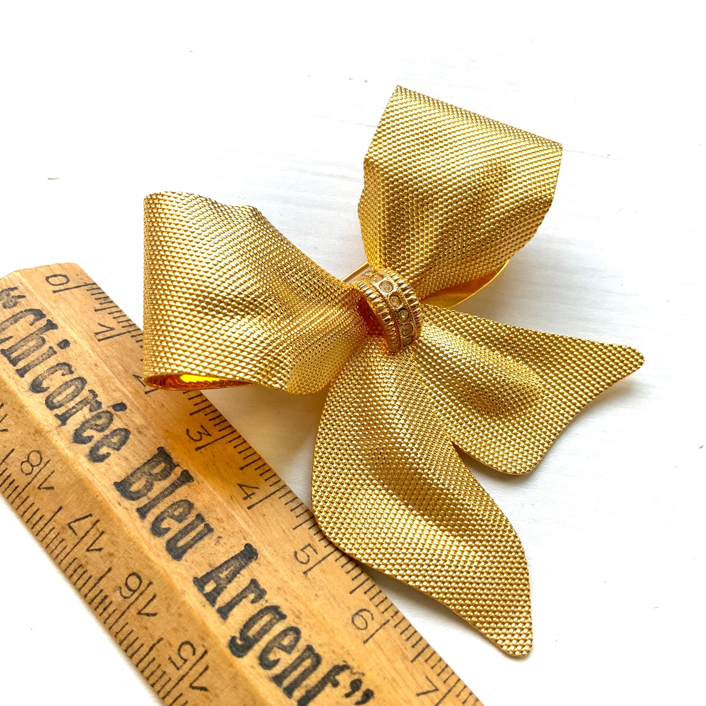 Vintage brooch in the shape of a large gold-tone bow. 大きなゴールドトーンメタルのリボンのブローチ。