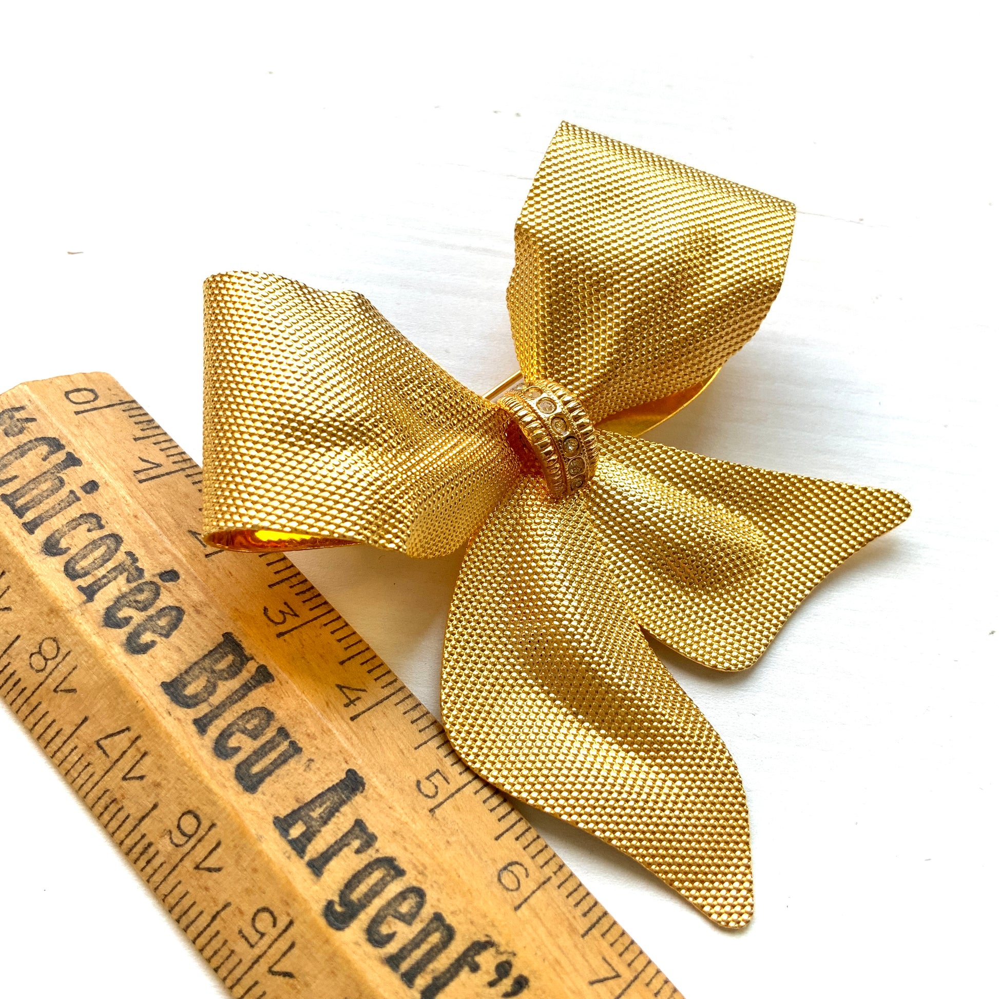 Vintage brooch in the shape of a large gold-tone bow. 大きなゴールドトーンメタルのリボンのブローチ。