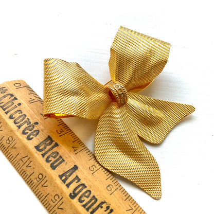 Vintage brooch in the shape of a large gold-tone bow. 大きなゴールドトーンメタルのリボンのブローチ。