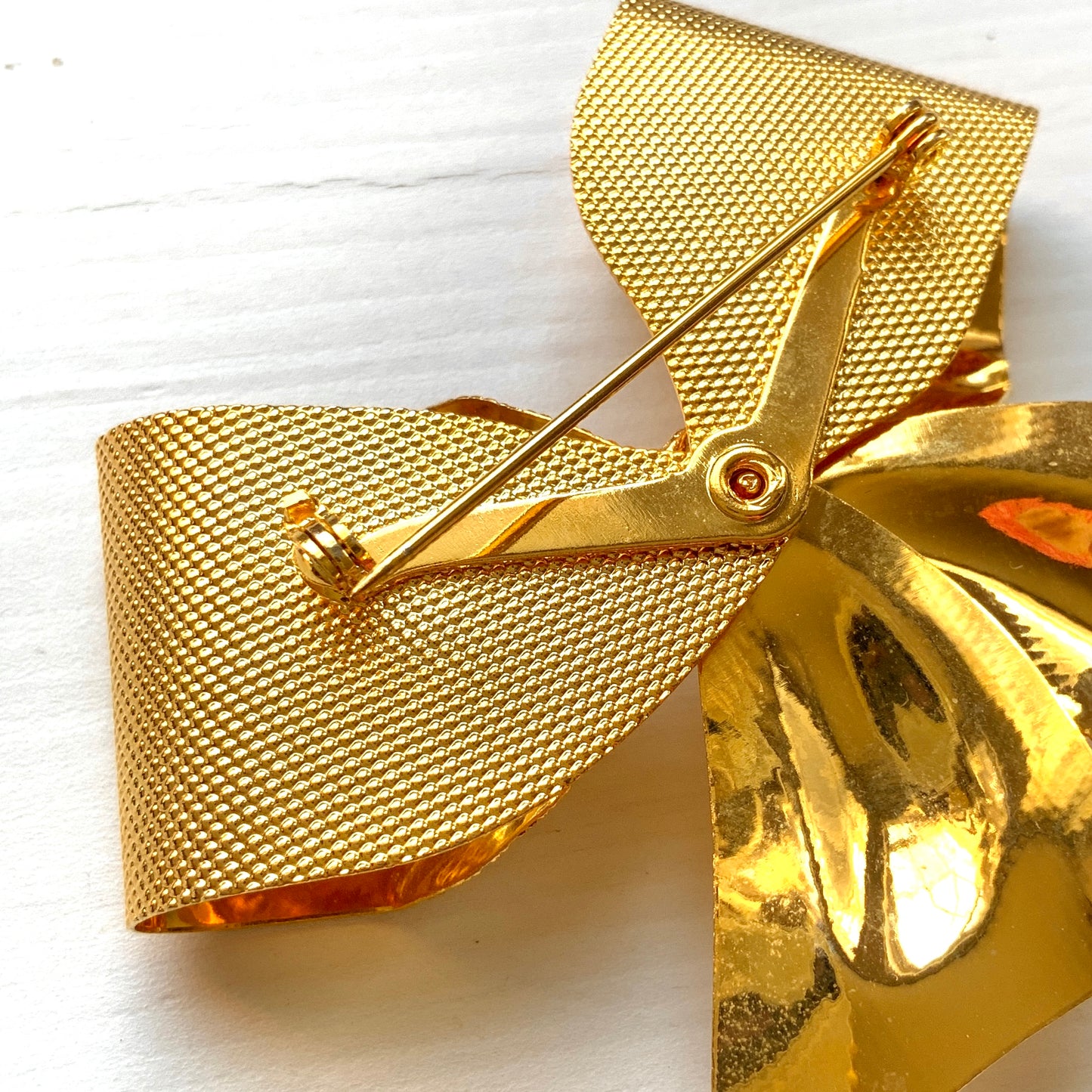 Vintage brooch in the shape of a large gold-tone bow. 大きなゴールドトーンメタルのリボンのブローチ。