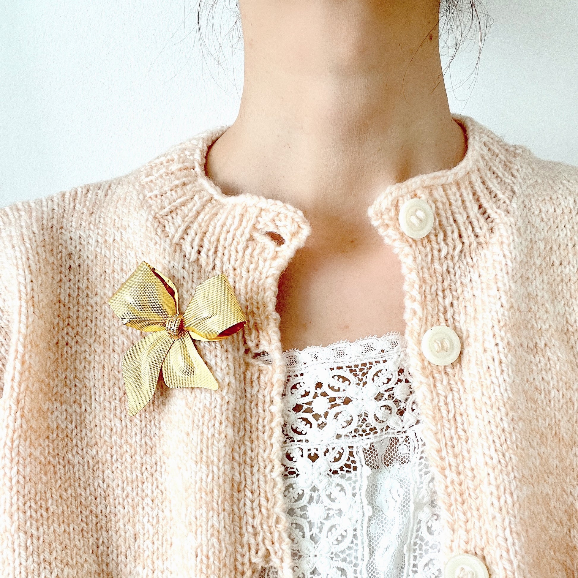 Vintage brooch in the shape of a large gold-tone bow. 大きなゴールドトーンメタルのリボンのブローチ。