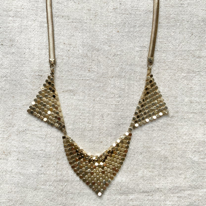 Gold-tone necklace featuring a combination of triangular metal mesh panels. 三角形のメタルメッシュを組み合わせた、ゴールドトーンのネックレス。