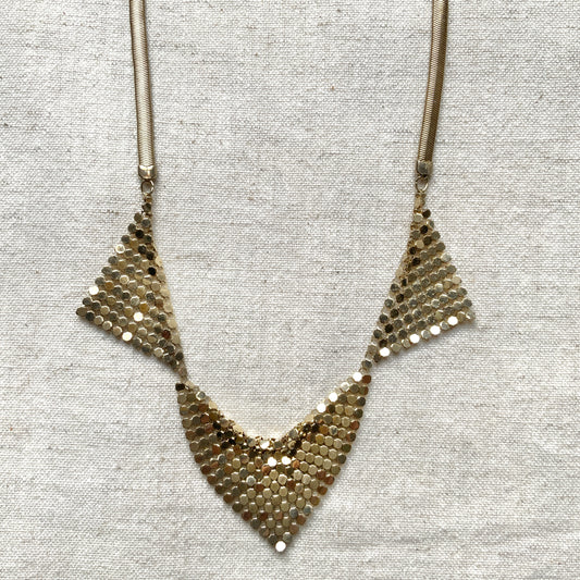 Gold-tone necklace featuring a combination of triangular metal mesh panels. 三角形のメタルメッシュを組み合わせた、ゴールドトーンのネックレス。