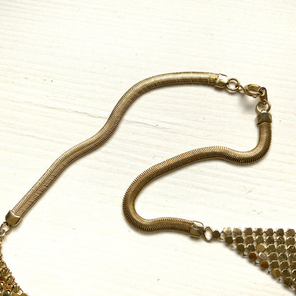 Gold-tone necklace featuring a combination of triangular metal mesh panels. 三角形のメタルメッシュを組み合わせた、ゴールドトーンのネックレス。