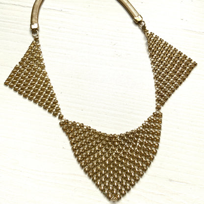 Gold-tone necklace featuring a combination of triangular metal mesh panels. 三角形のメタルメッシュを組み合わせた、ゴールドトーンのネックレス。
