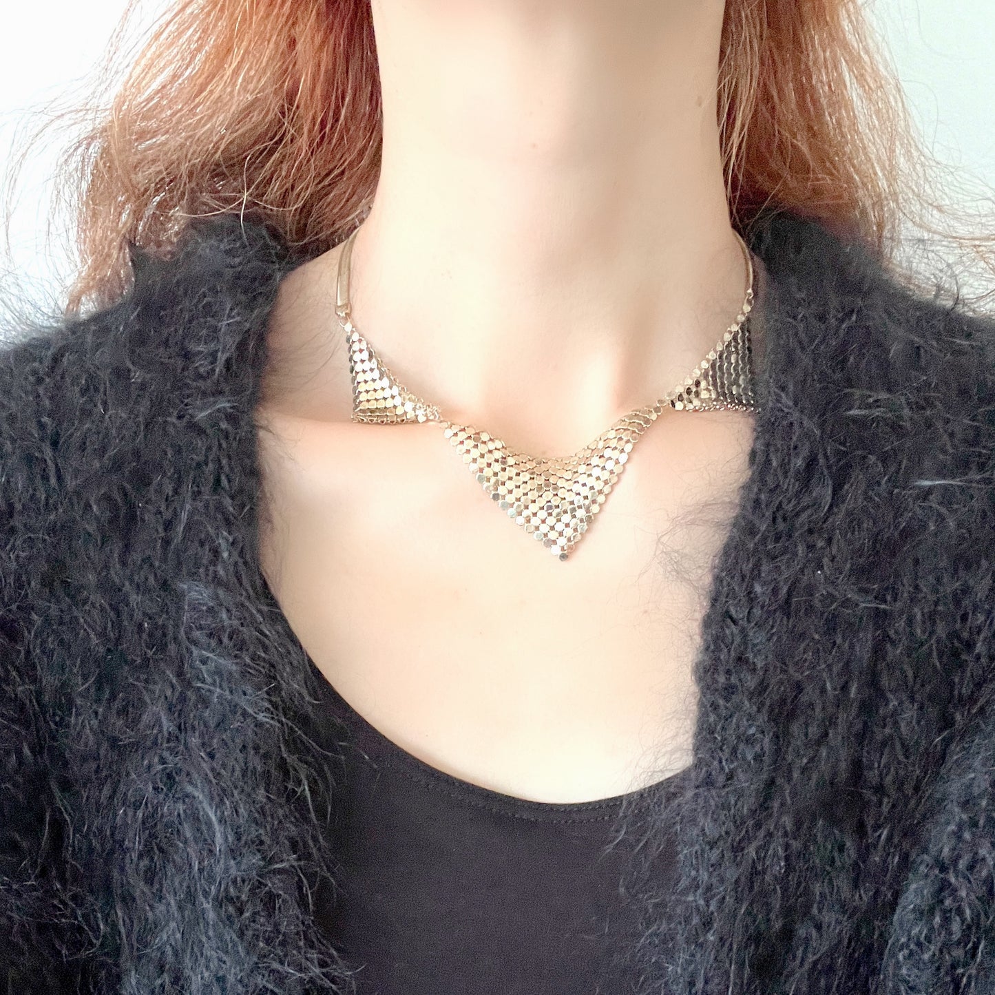 Gold-tone necklace featuring a combination of triangular metal mesh panels. 三角形のメタルメッシュを組み合わせた、ゴールドトーンのネックレス。
