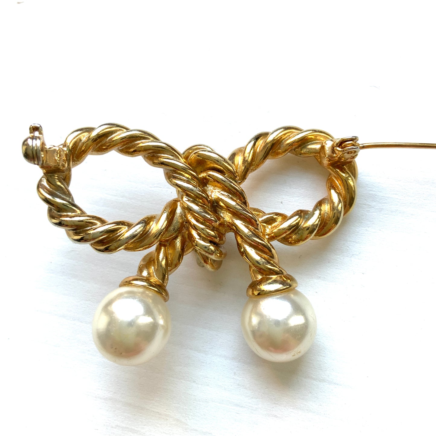 Vintage bow brooch in a twisted gold-tone rope design. ゴールドトーンメタルのツイストロープでリボンを象ったブローチ。