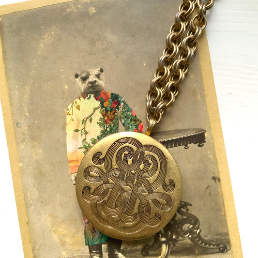 A vintage Monet locket necklace featuring an eye-catching woven-style scroll pattern.  編み込まれたような曲線模様が印象的な、Monet（モネ）のヴィンテージロケットネックレス。