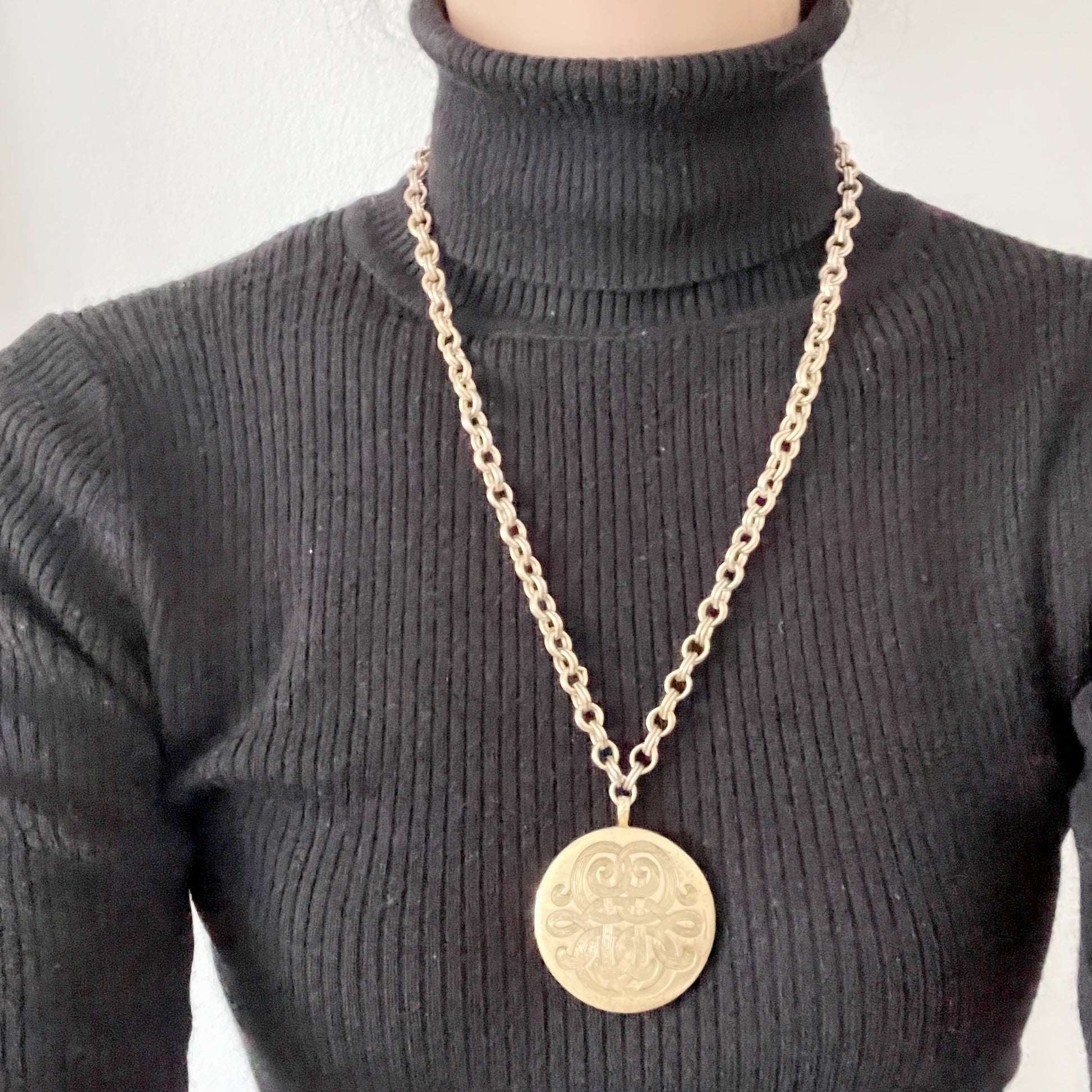 A vintage Monet locket necklace featuring an eye-catching woven-style scroll pattern.  編み込まれたような曲線模様が印象的な、Monet（モネ）のヴィンテージロケットネックレス。