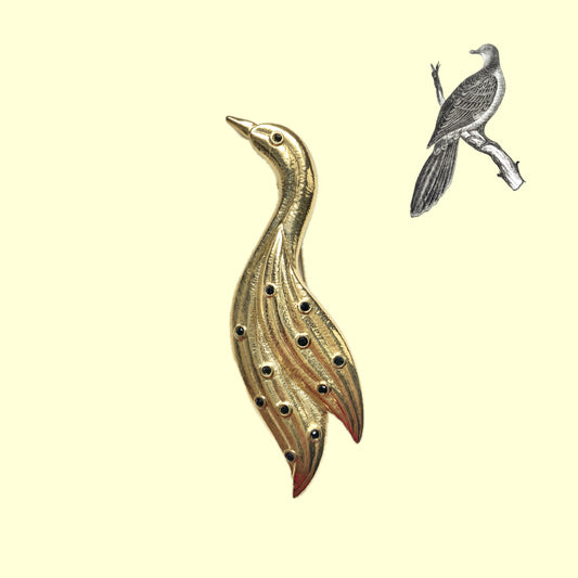 A graceful bird brooch defined by its smooth, flowing lines.  なめらかな曲線で描かれたフォルムが優雅な、鳥のブローチ。