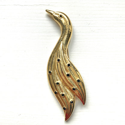 A graceful bird brooch defined by its smooth, flowing lines.  なめらかな曲線で描かれたフォルムが優雅な、鳥のブローチ。