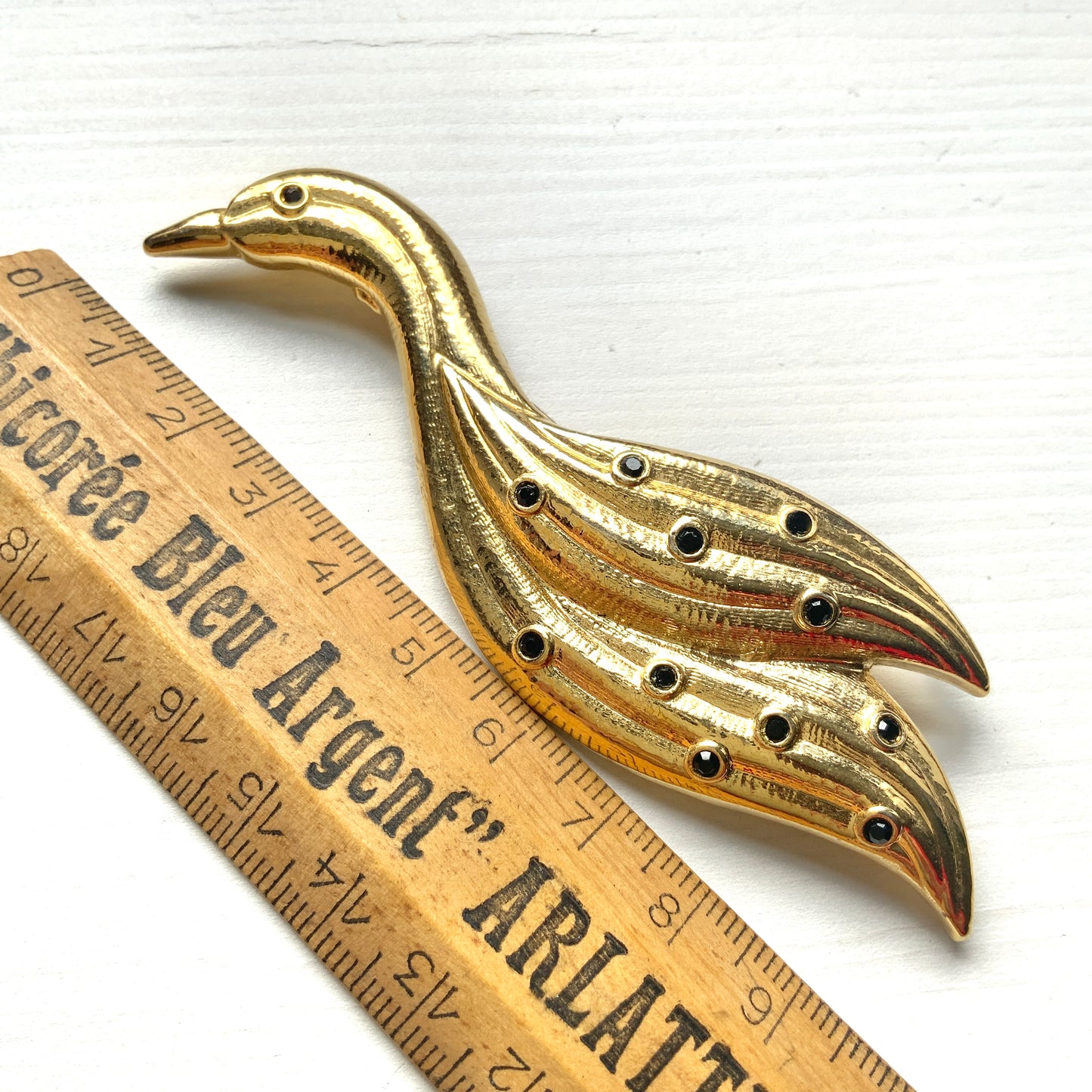 A graceful bird brooch defined by its smooth, flowing lines.  なめらかな曲線で描かれたフォルムが優雅な、鳥のブローチ。
