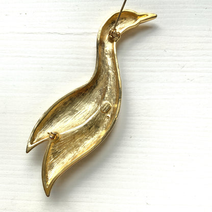 A graceful bird brooch defined by its smooth, flowing lines.  なめらかな曲線で描かれたフォルムが優雅な、鳥のブローチ。
