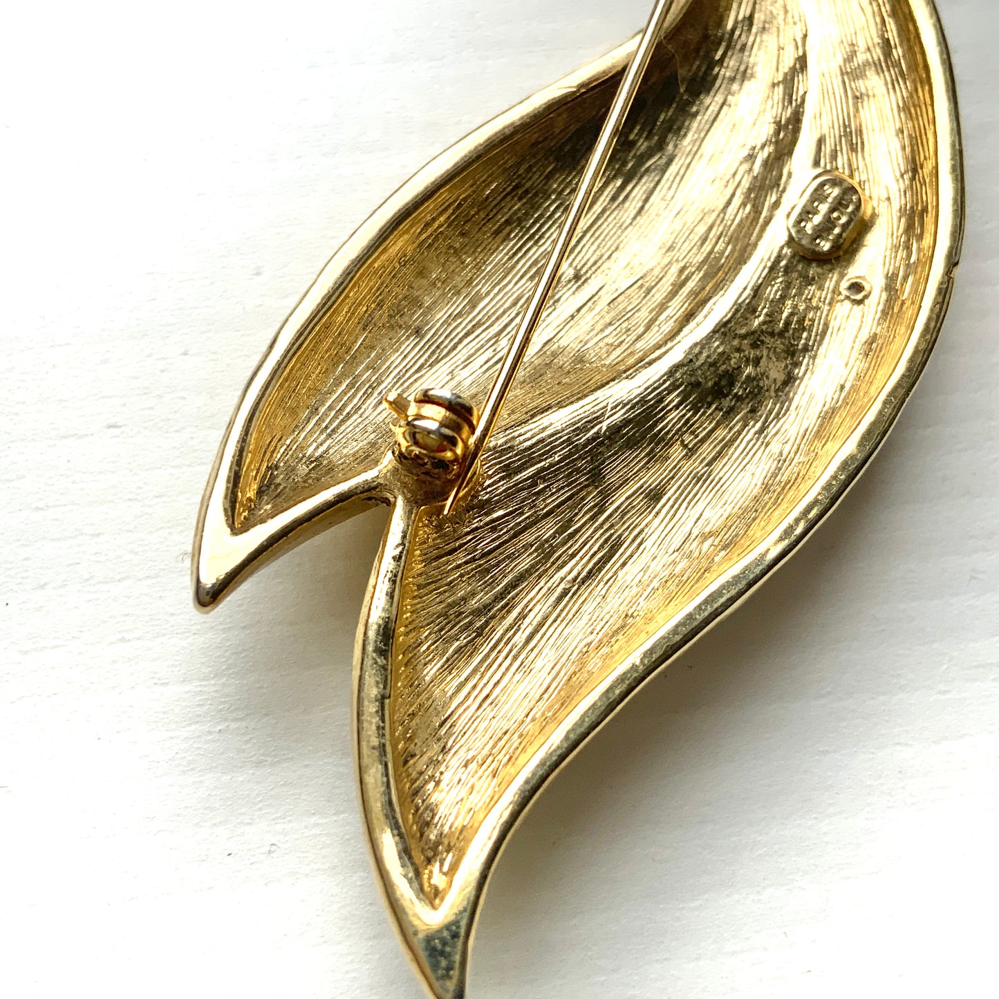 A graceful bird brooch defined by its smooth, flowing lines.  なめらかな曲線で描かれたフォルムが優雅な、鳥のブローチ。