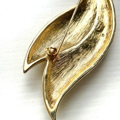 A graceful bird brooch defined by its smooth, flowing lines.  なめらかな曲線で描かれたフォルムが優雅な、鳥のブローチ。