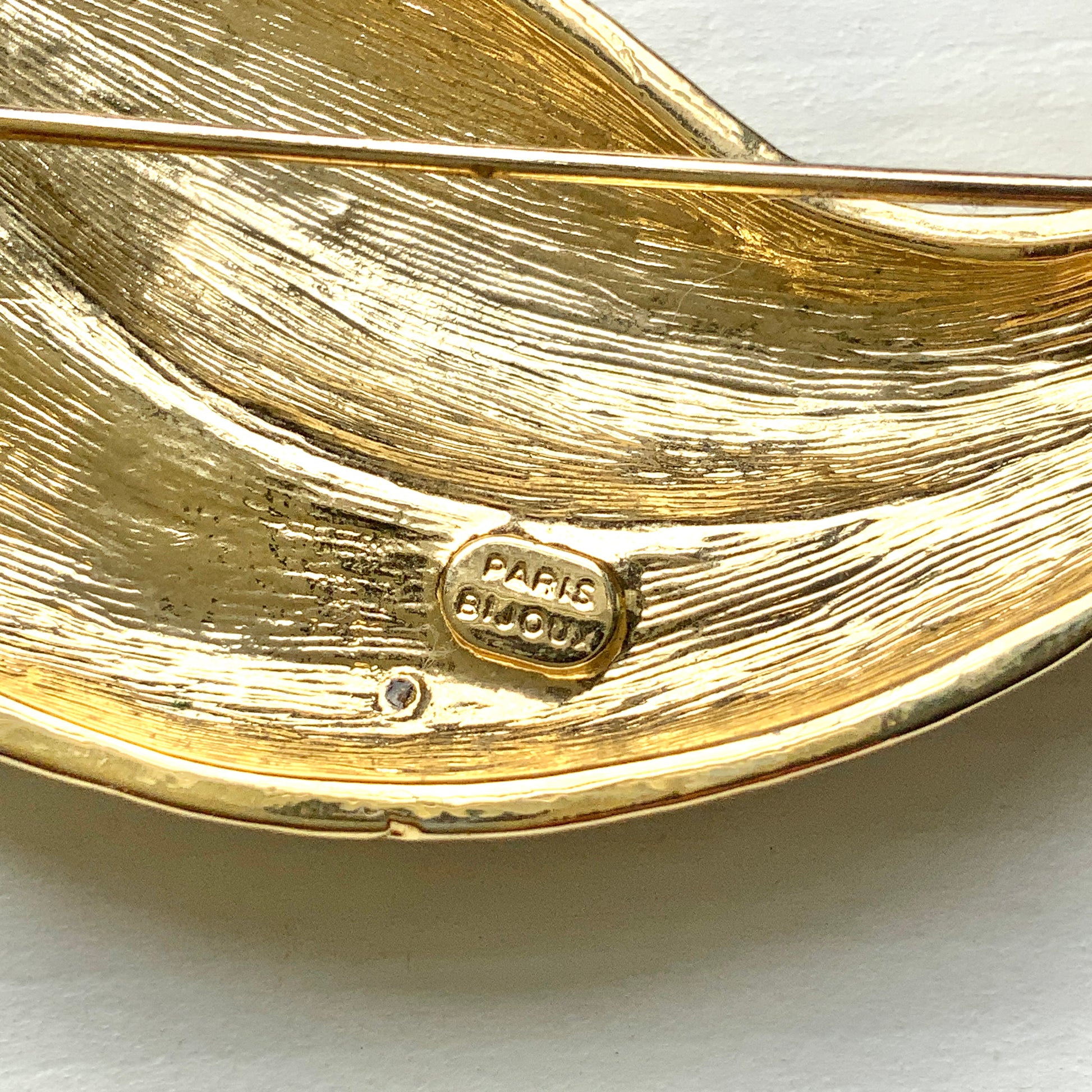 A graceful bird brooch defined by its smooth, flowing lines.  なめらかな曲線で描かれたフォルムが優雅な、鳥のブローチ。