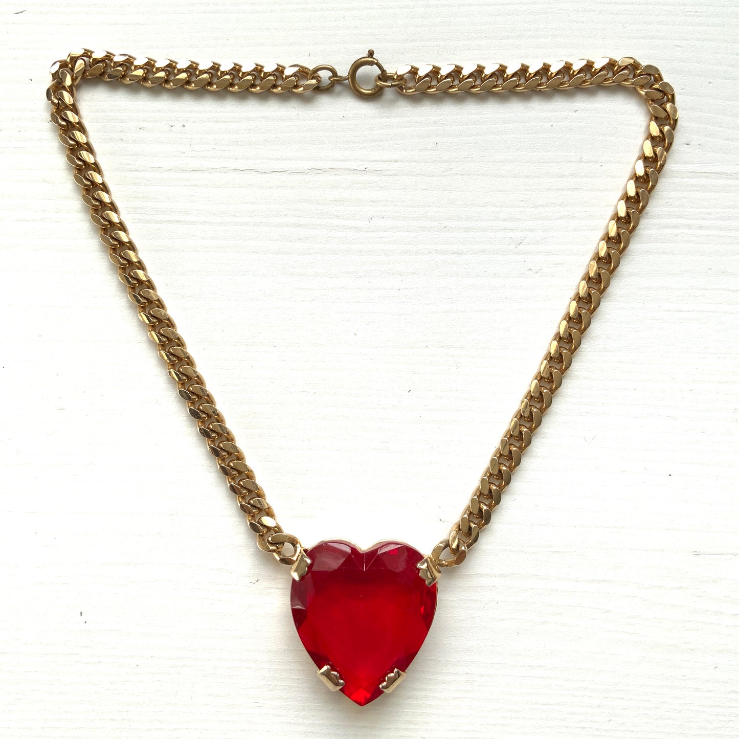 A necklace featuring a large, vibrant red glass heart that immediately draws the eye. 大きく鮮やかなレッドハートのグラスビジューが目を引くネックレス。