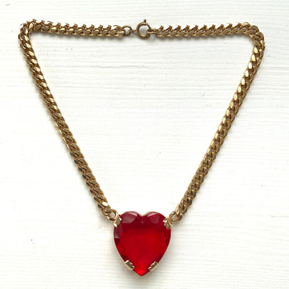 A necklace featuring a large, vibrant red glass heart that immediately draws the eye. 大きく鮮やかなレッドハートのグラスビジューが目を引くネックレス。