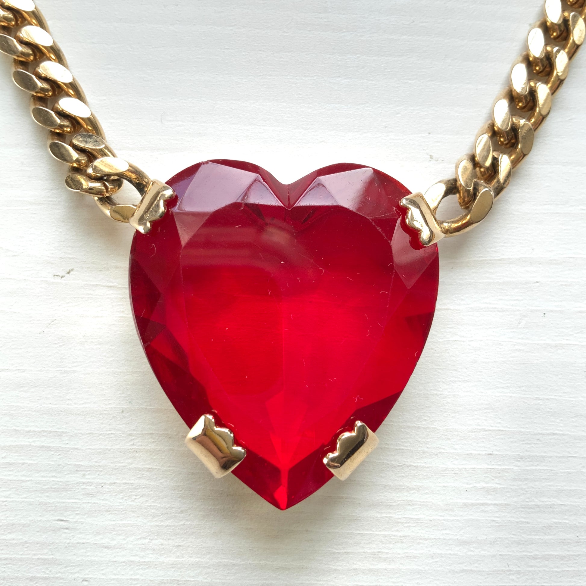 A necklace featuring a large, vibrant red glass heart that immediately draws the eye. 大きく鮮やかなレッドハートのグラスビジューが目を引くネックレス。