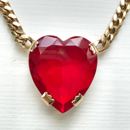 A necklace featuring a large, vibrant red glass heart that immediately draws the eye. 大きく鮮やかなレッドハートのグラスビジューが目を引くネックレス。