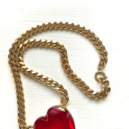 A necklace featuring a large, vibrant red glass heart that immediately draws the eye. 大きく鮮やかなレッドハートのグラスビジューが目を引くネックレス。
