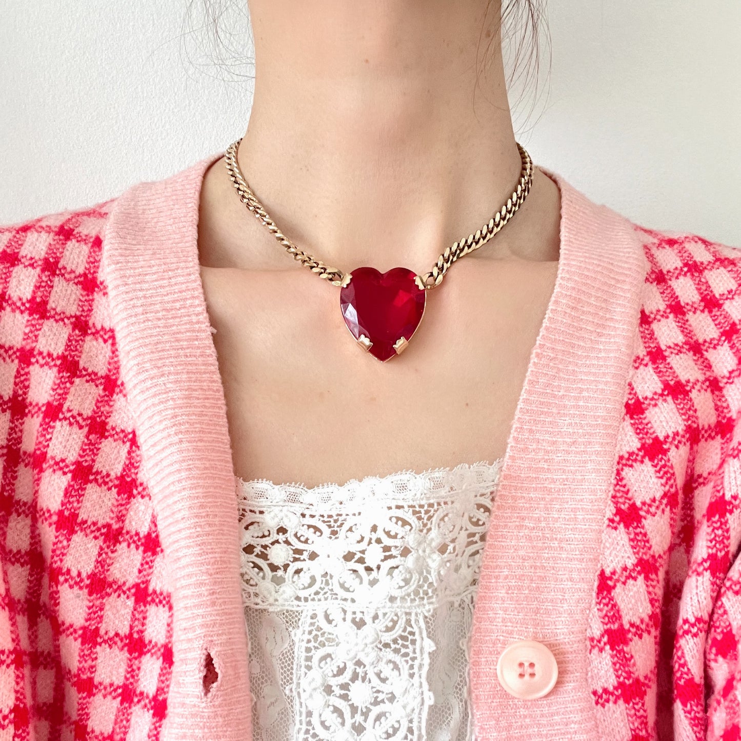 A necklace featuring a large, vibrant red glass heart that immediately draws the eye. 大きく鮮やかなレッドハートのグラスビジューが目を引くネックレス。