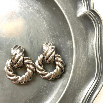 Twisted silver-tone metal door knocker-style clip-on earrings. ツイストされたシルバートーンメタルのドアノッカー型クリップイヤリング。