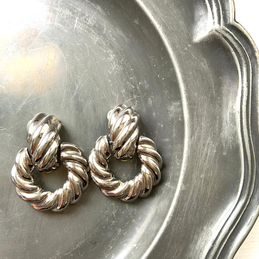 Twisted silver-tone metal door knocker-style clip-on earrings. ツイストされたシルバートーンメタルのドアノッカー型クリップイヤリング。