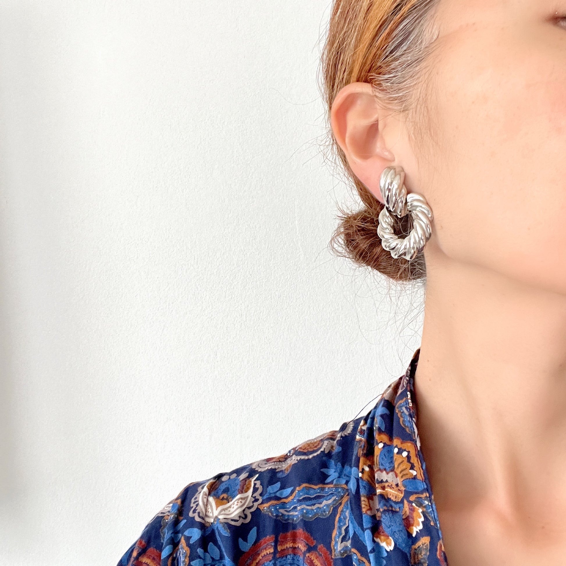 Twisted silver-tone metal door knocker-style clip-on earrings. ツイストされたシルバートーンメタルのドアノッカー型クリップイヤリング。