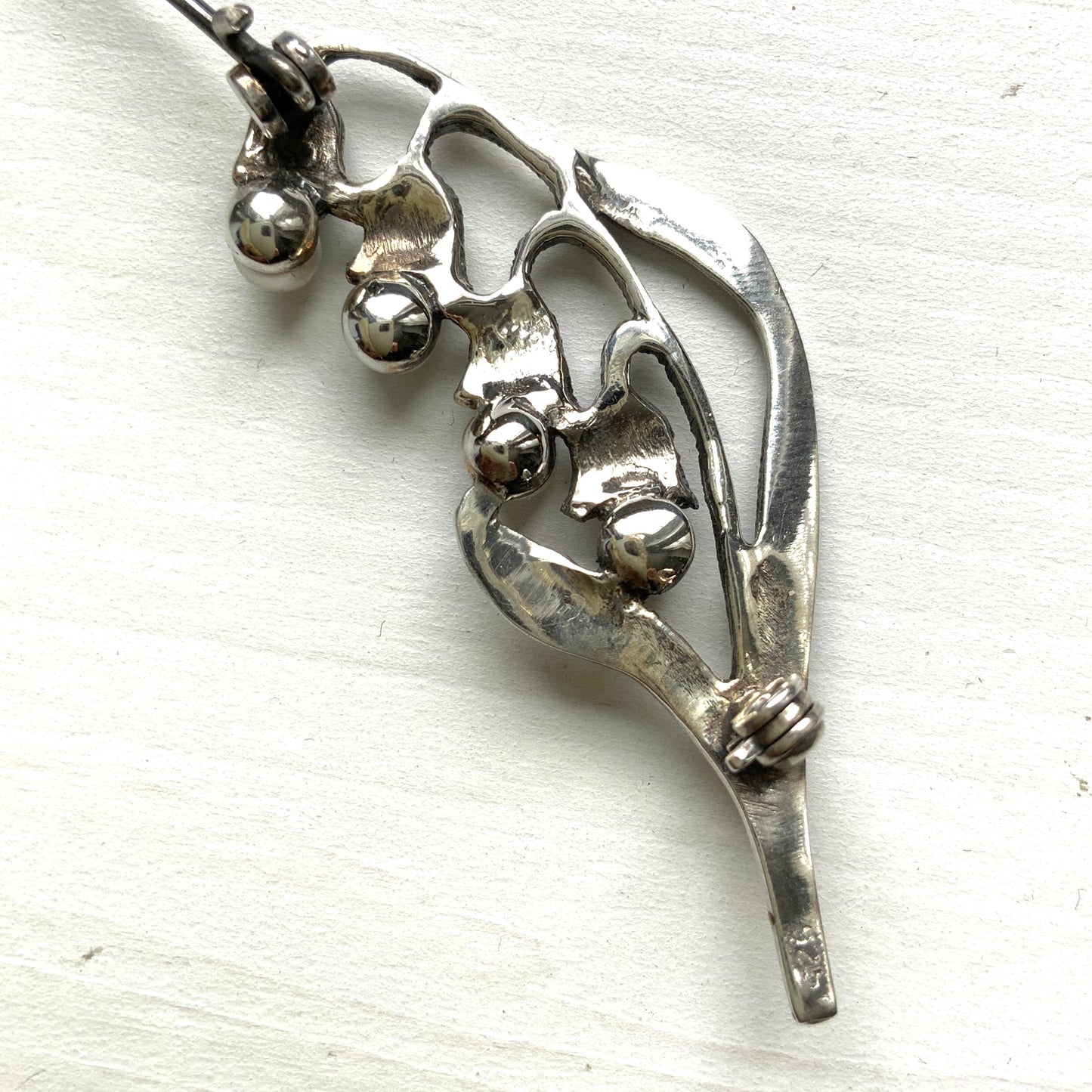 A silver brooch featuring lily of the valley set with pearls. パールがあしらわれたスズランモチーフのシルバーブローチ。
