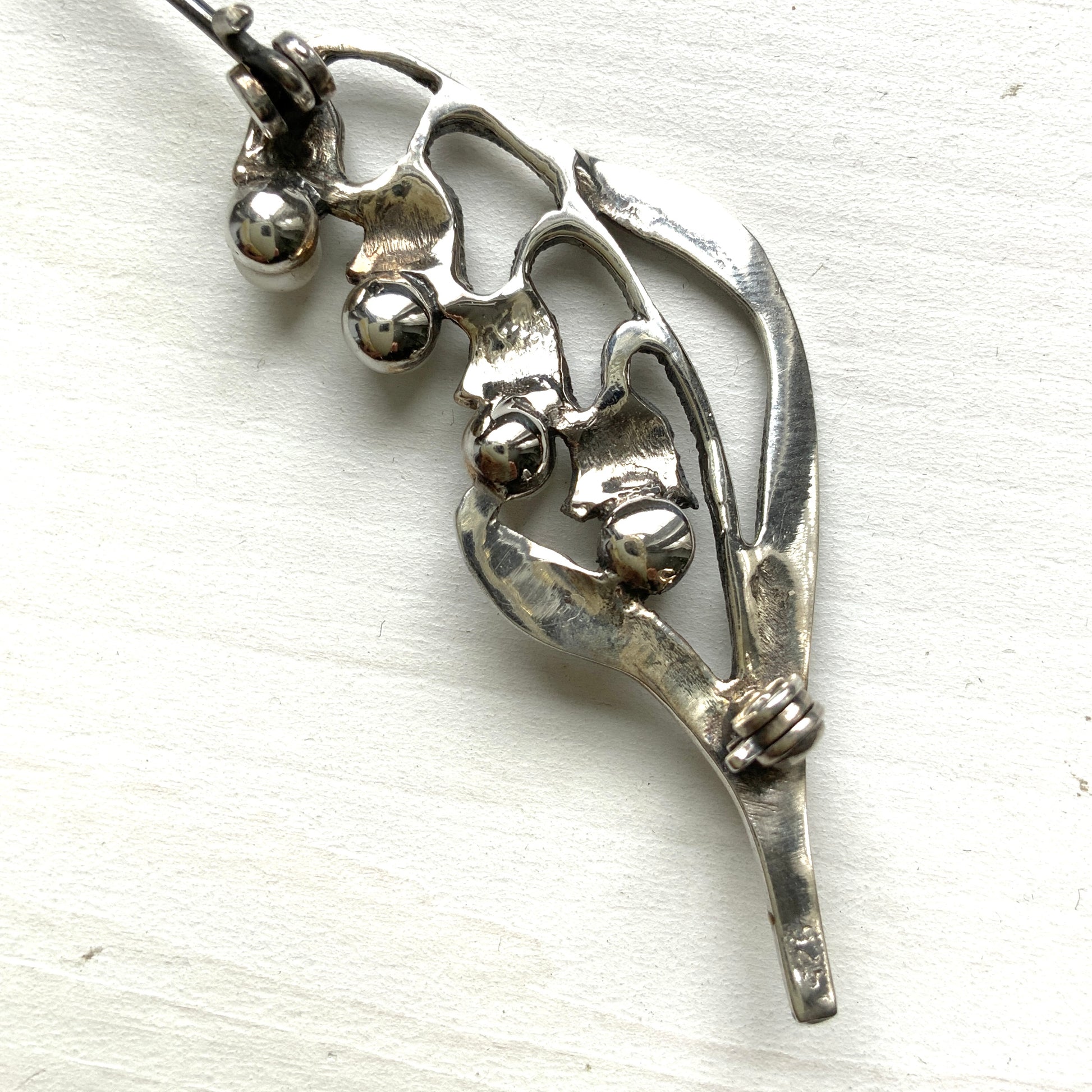 A silver brooch featuring lily of the valley set with pearls. パールがあしらわれたスズランモチーフのシルバーブローチ。