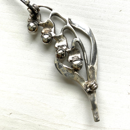 A silver brooch featuring lily of the valley set with pearls. パールがあしらわれたスズランモチーフのシルバーブローチ。