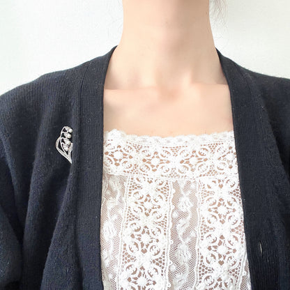 A silver brooch featuring lily of the valley set with pearls. パールがあしらわれたスズランモチーフのシルバーブローチ。