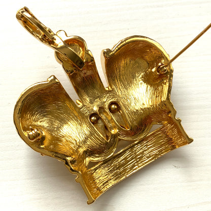 A crown brooch adorned with pearl cabochons and clear rhinestones on gold-tone metal. ゴールドトーンメタルに、パールカボションやクリアラインストーンがふんだんにあしらわれたクラウンブローチ。