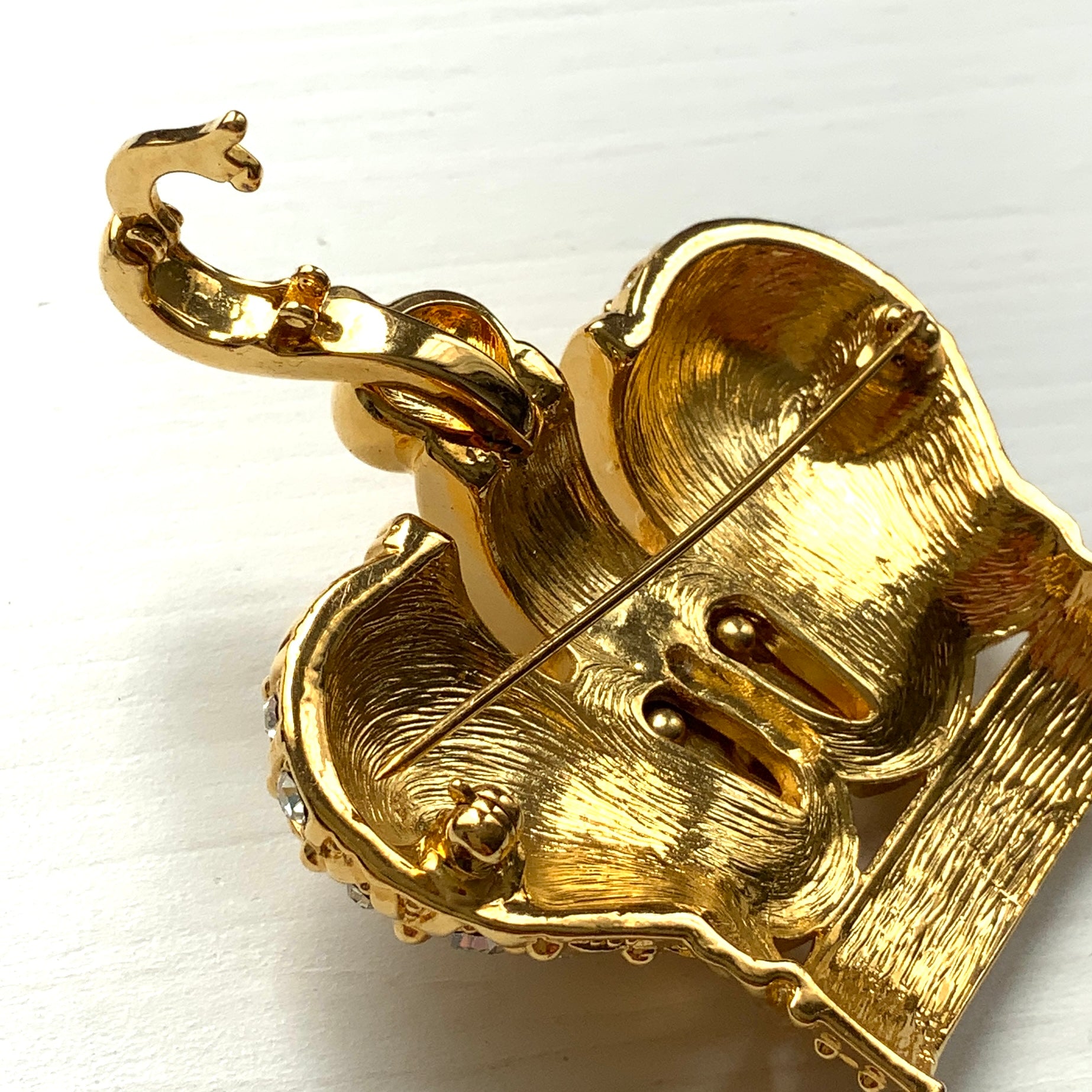 A crown brooch adorned with pearl cabochons and clear rhinestones on gold-tone metal. ゴールドトーンメタルに、パールカボションやクリアラインストーンがふんだんにあしらわれたクラウンブローチ。