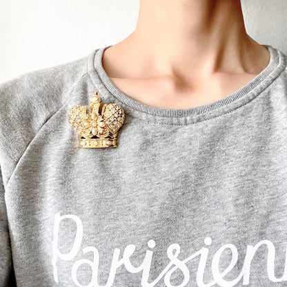 A crown brooch adorned with pearl cabochons and clear rhinestones on gold-tone metal. ゴールドトーンメタルに、パールカボションやクリアラインストーンがふんだんにあしらわれたクラウンブローチ。