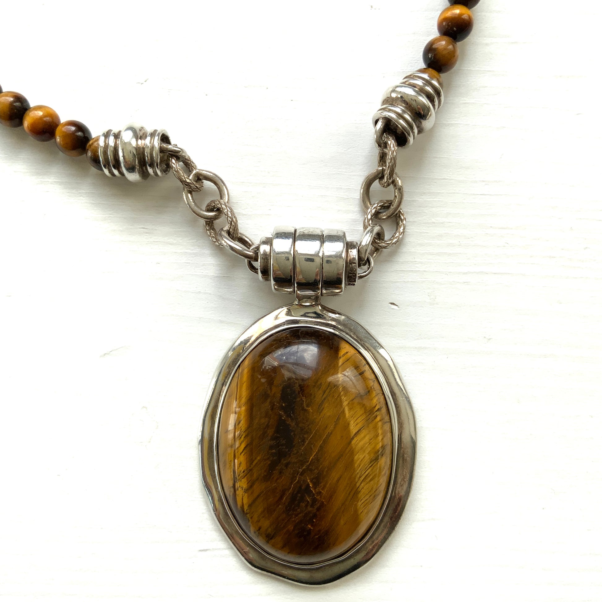 A bold oval-shaped tiger's eye stone takes centre stage in this striking silver necklace by Joseph Esposito. 大ぶりのオーバル型タイガーアイが印象的な、ジョセフ・エスポジートによるシルバーネックレス。