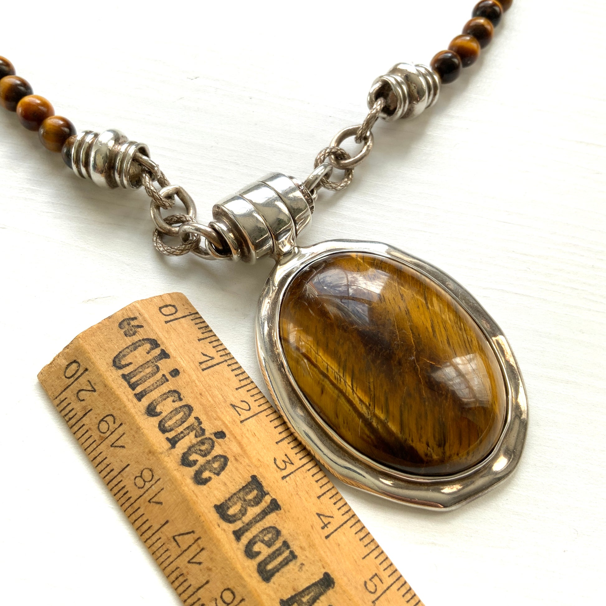 A bold oval-shaped tiger's eye stone takes centre stage in this striking silver necklace by Joseph Esposito. 大ぶりのオーバル型タイガーアイが印象的な、ジョセフ・エスポジートによるシルバーネックレス。
