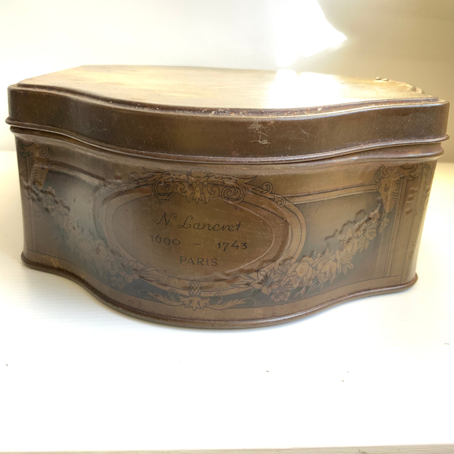 A French confectionery tin featuring a beautiful 18th-century illustration, with an elegant shape and refined design.  18世紀の美しいイラストがプリントされた、優雅なシェイプとデザインのフランスの菓子缶。