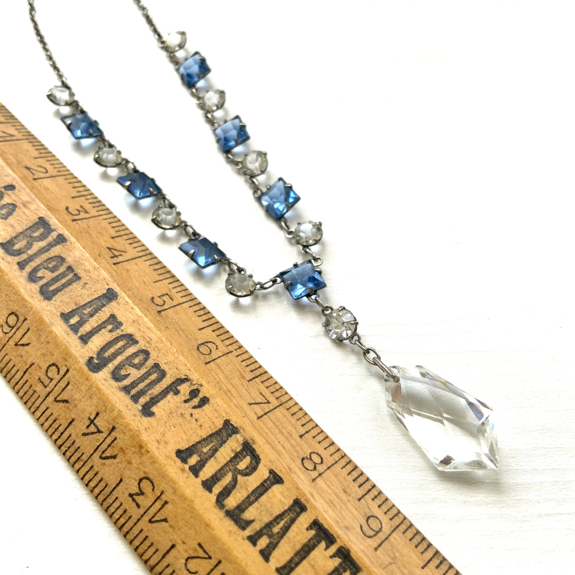 A vintage necklace featuring alternating blue and clear glass stones. ブルーとクリアのグラスを連ねたヴィンテージネックレス。