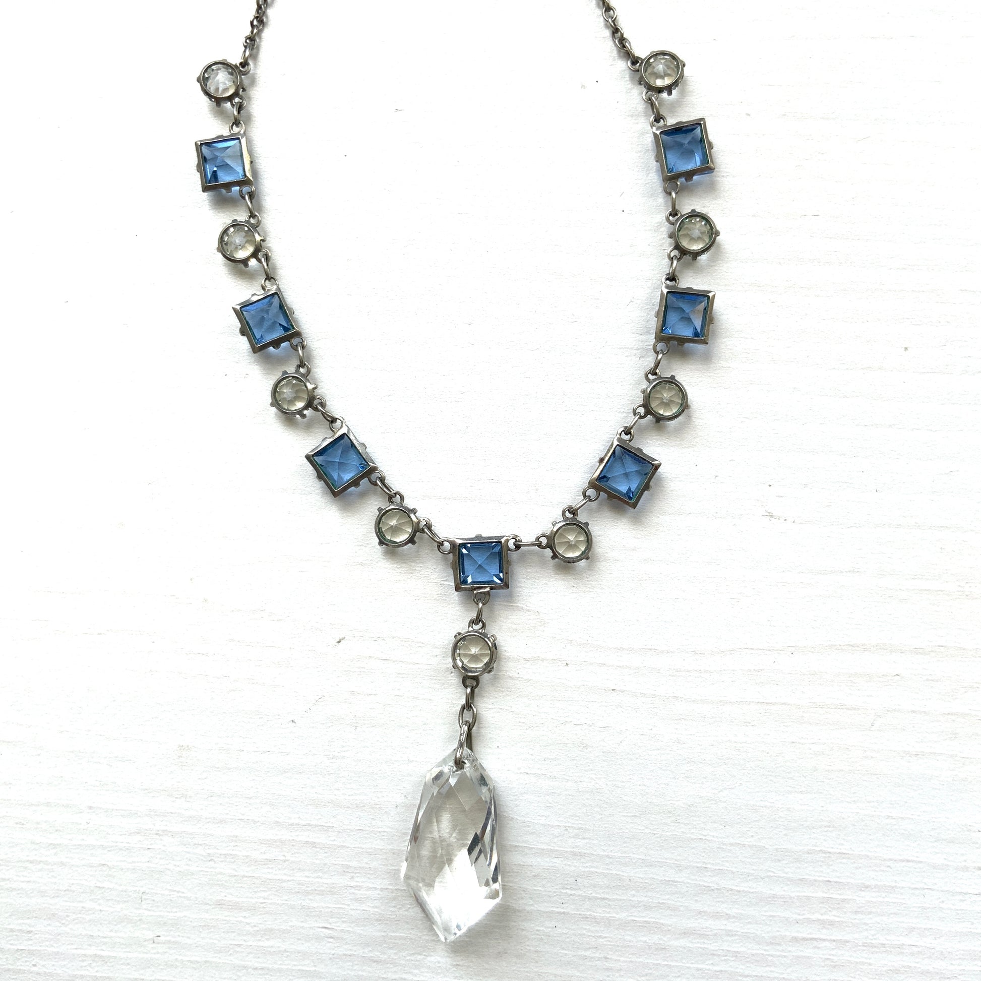 A vintage necklace featuring alternating blue and clear glass stones. ブルーとクリアのグラスを連ねたヴィンテージネックレス。