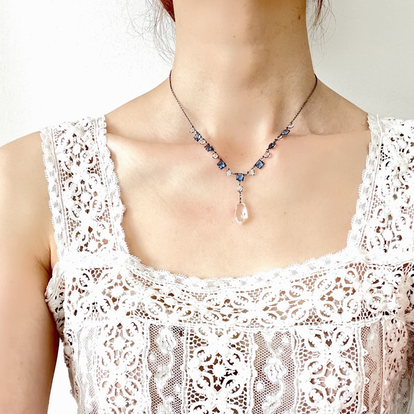 A vintage necklace featuring alternating blue and clear glass stones. ブルーとクリアのグラスを連ねたヴィンテージネックレス。