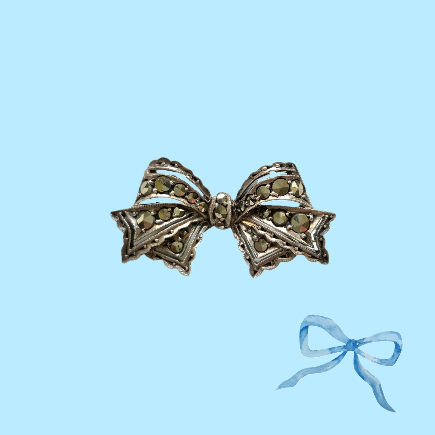 A small bow brooch set with marcasites in silver. シルバーにマーカサイトがあしらわれた小さなリボンのブローチ。 