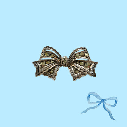 A small bow brooch set with marcasites in silver. シルバーにマーカサイトがあしらわれた小さなリボンのブローチ。 