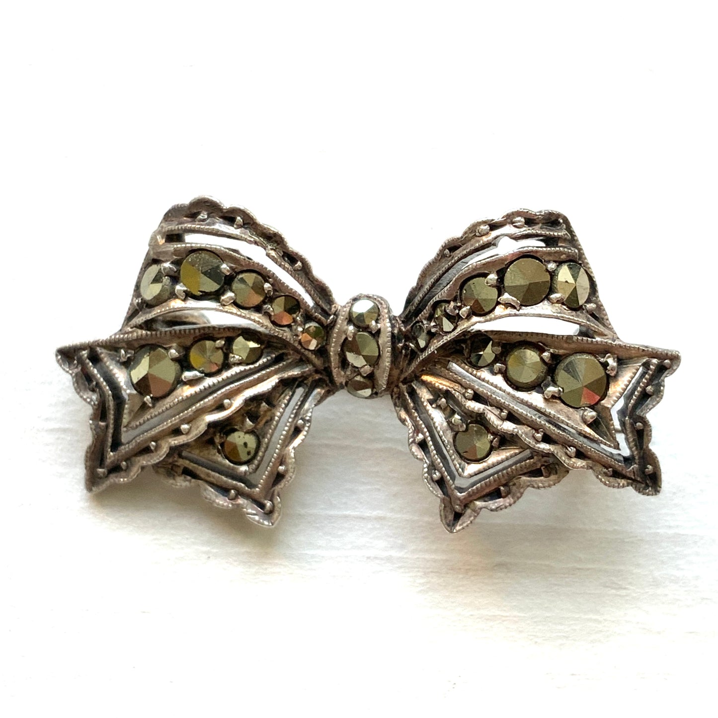 A small bow brooch set with marcasites in silver. シルバーにマーカサイトがあしらわれた小さなリボンのブローチ。 