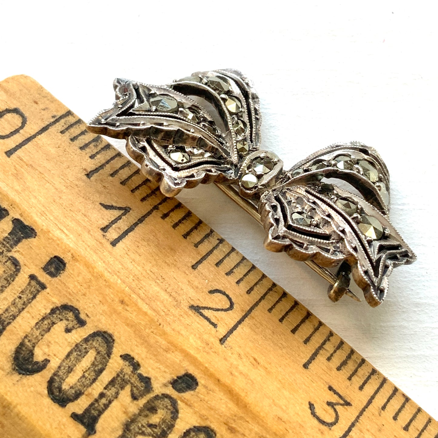 A small bow brooch set with marcasites in silver. シルバーにマーカサイトがあしらわれた小さなリボンのブローチ。 